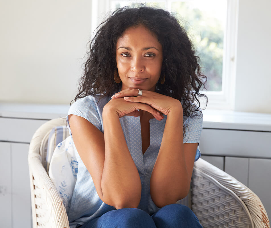 Woman smiling while resting her chin on her hands